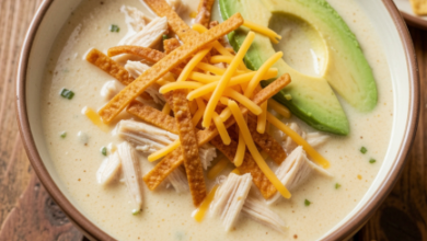 Creamy chicken tortilla soup topped with crispy tortilla strips, avocado, cheddar cheese, and fresh cilantro.